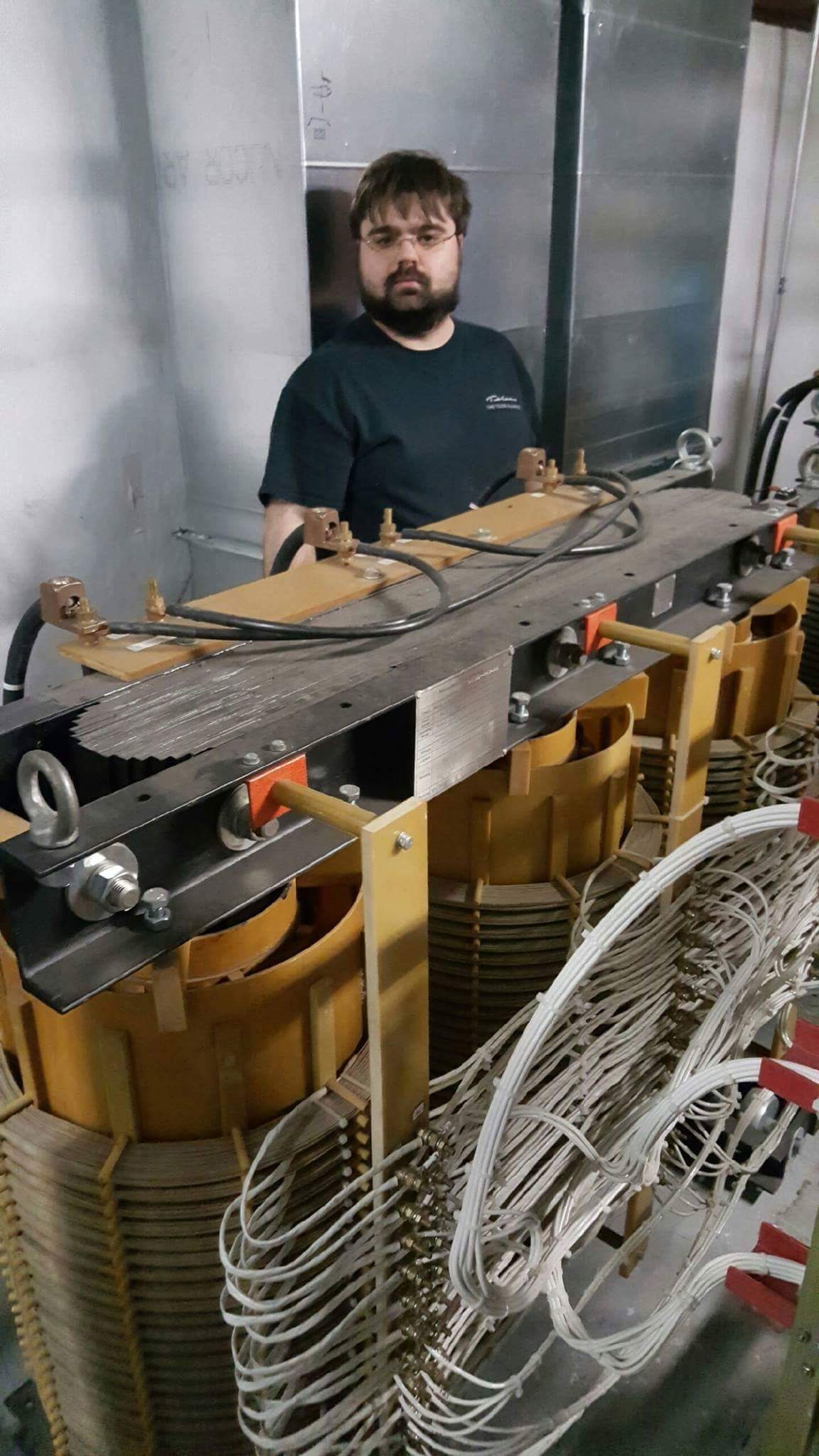 MATT BEHIND ONE OF TRANSMITTER 1 POWER MODULATION TRANSFORMERS